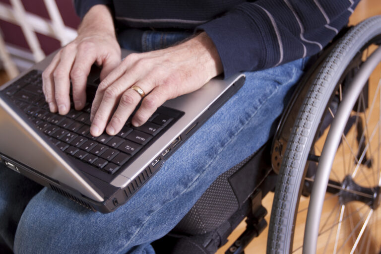 man in wheelchair using laptop