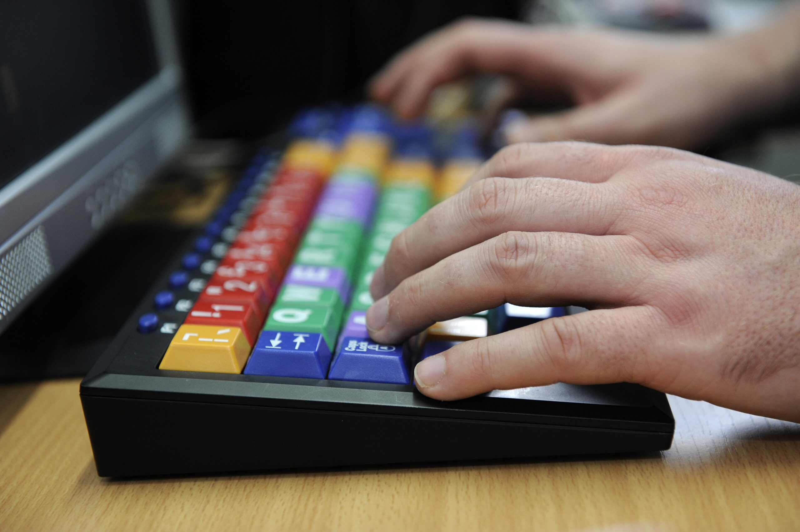 An image of two hands typing on a computer keyboard for visually impaired people.
