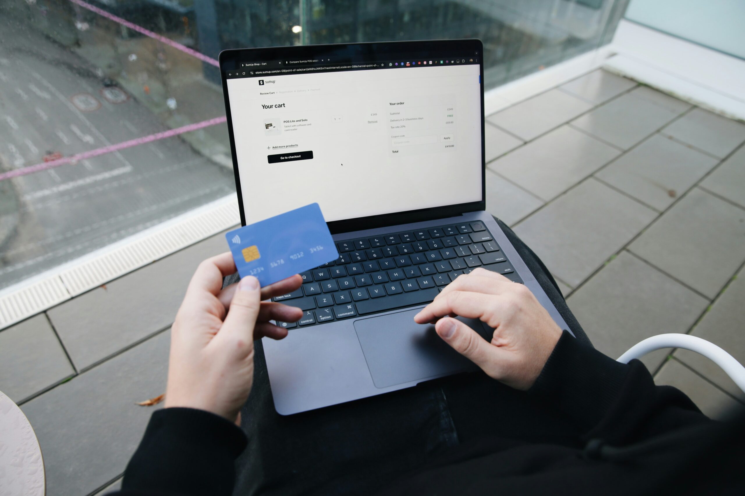 a person holding a laptop and bank card